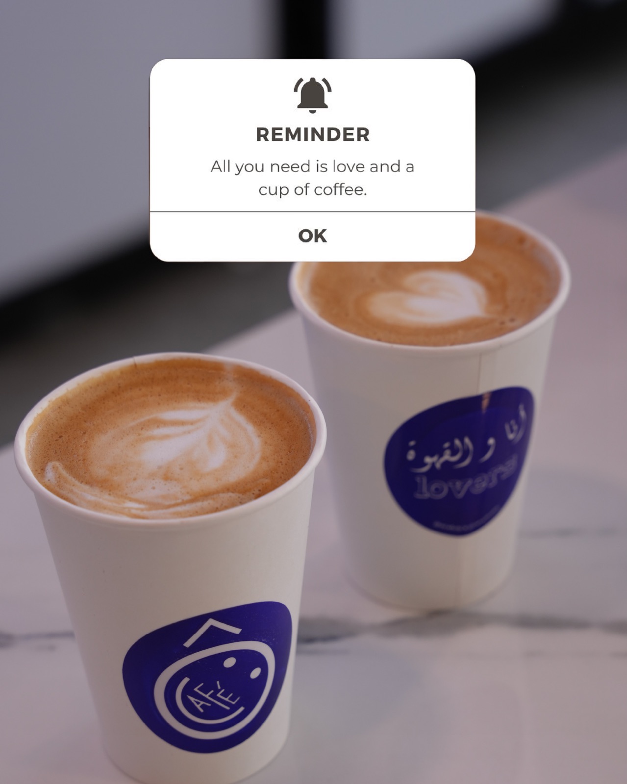 Two flat whites with heart latte art in Ô café paper cups on marble